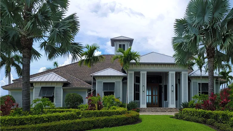 Luxurious modern mansion surrounded by lush greenery and palm trees, ideal for real estate promotion.